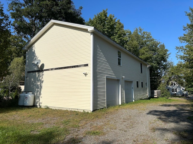 view of side of property with central AC unit and a garage