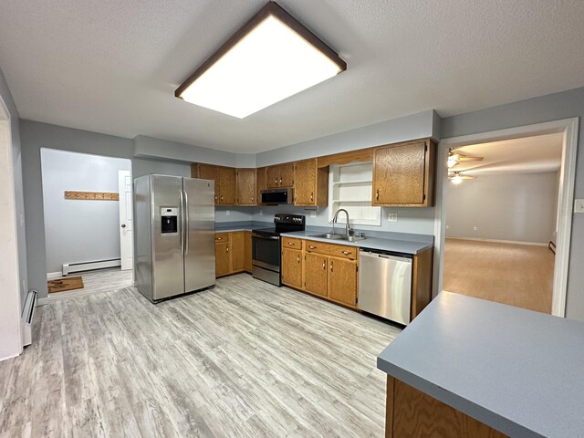 kitchen with a baseboard heating unit, light hardwood / wood-style floors, ceiling fan, and appliances with stainless steel finishes