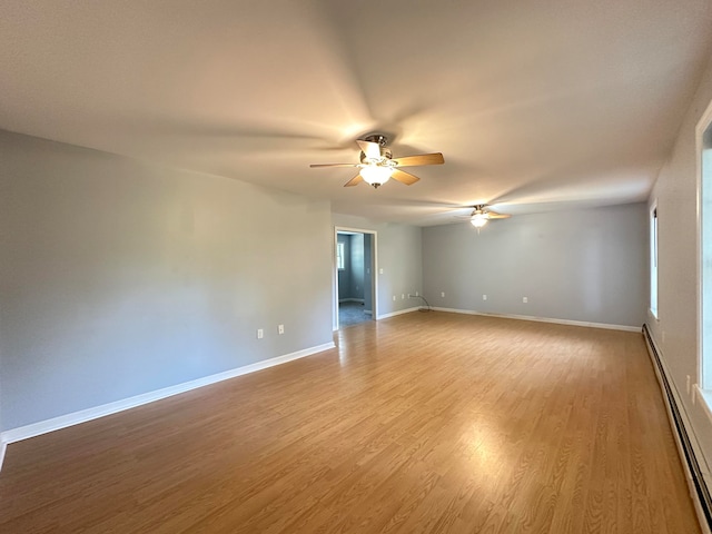 unfurnished room featuring a baseboard radiator, light hardwood / wood-style floors, and ceiling fan