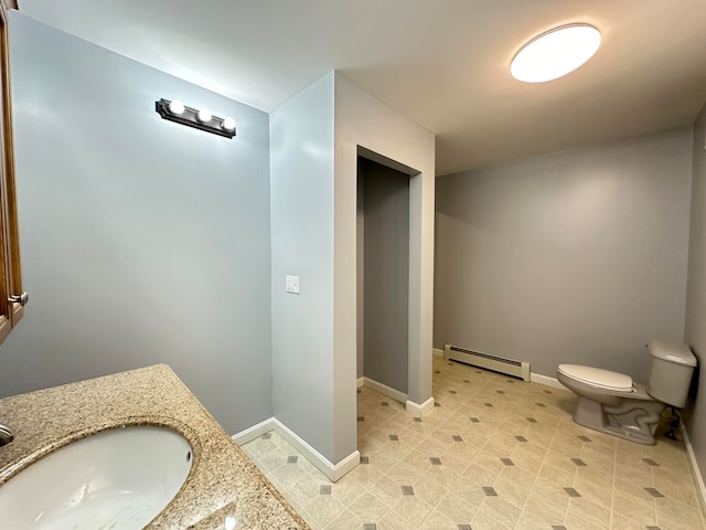 bathroom featuring baseboard heating, vanity, and toilet