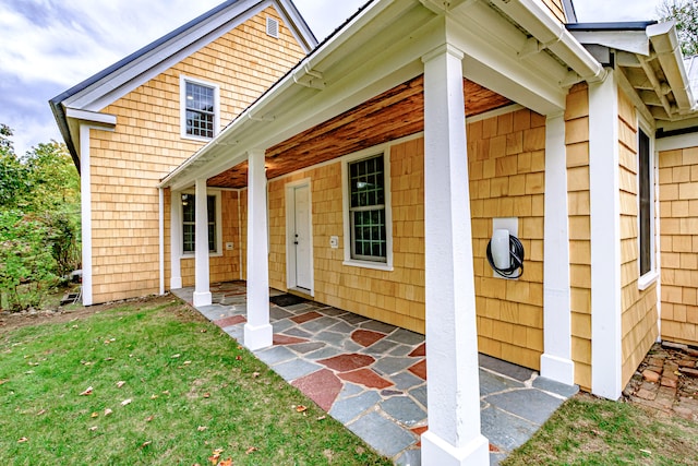 view of exterior entry featuring a yard