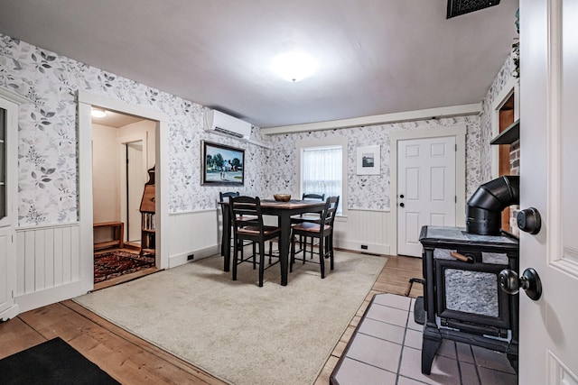 dining space with a wall mounted AC and hardwood / wood-style floors