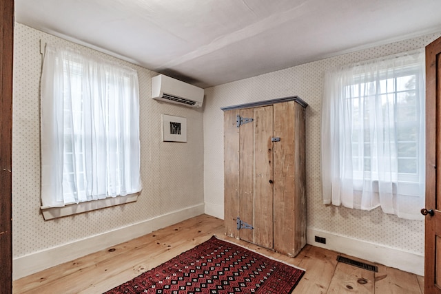 entryway with light hardwood / wood-style floors and a wall mounted air conditioner