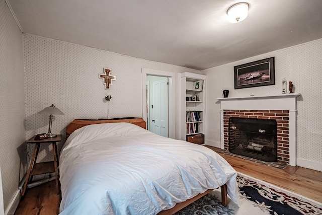 bedroom featuring a fireplace and wood-type flooring