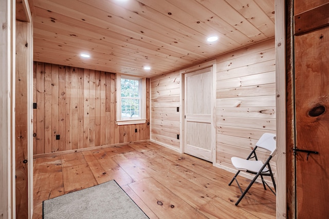 unfurnished room featuring light hardwood / wood-style flooring, wooden walls, and wood ceiling