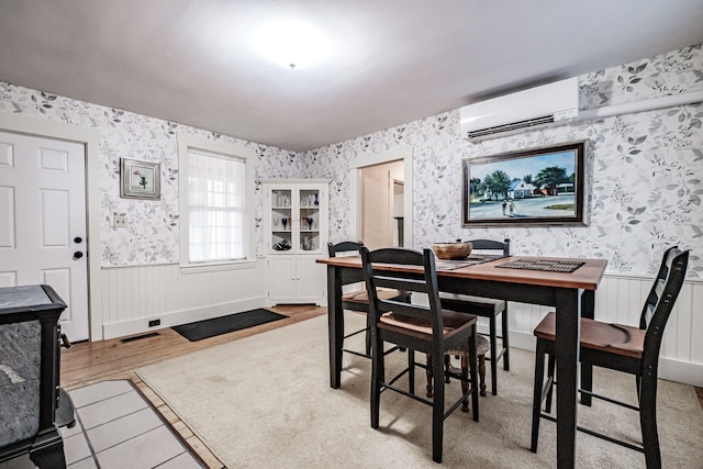 dining area featuring hardwood / wood-style flooring and a wall unit AC