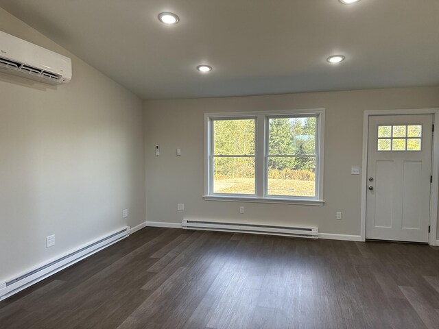 foyer entrance with dark hardwood / wood-style floors, baseboard heating, and a wall unit AC