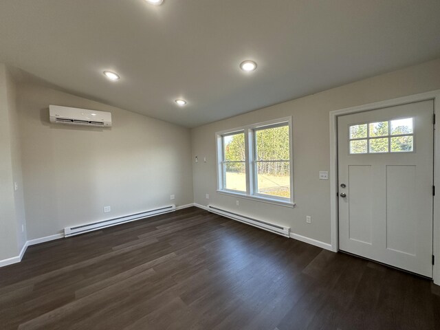 entryway with baseboard heating, a wall unit AC, and a wealth of natural light