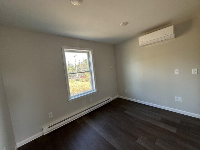 spare room featuring a wall unit AC, baseboard heating, and dark wood-type flooring