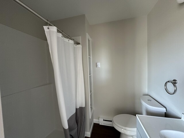 bathroom featuring vanity, toilet, and a baseboard heating unit