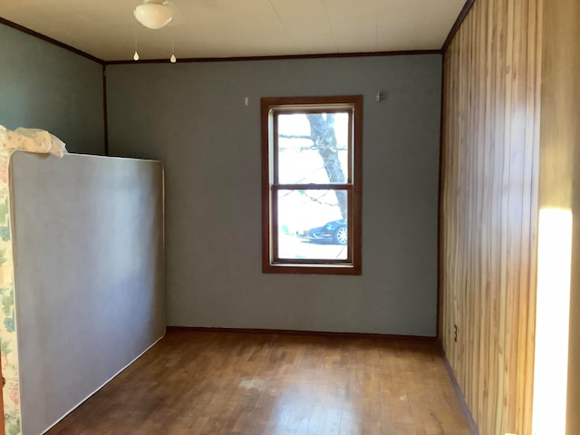 empty room with light wood-type flooring and ornamental molding