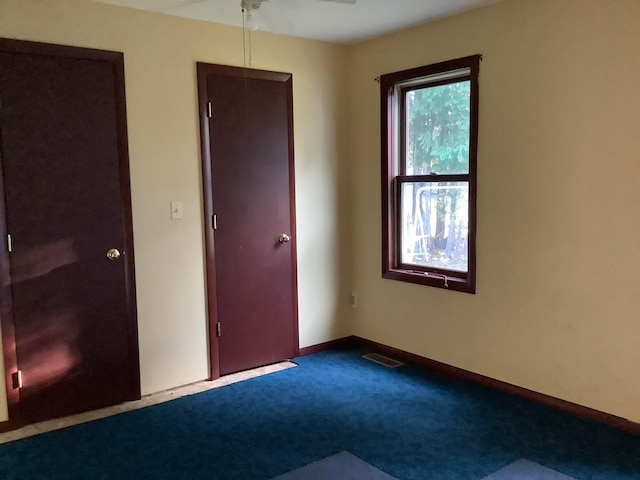 carpeted spare room with ceiling fan