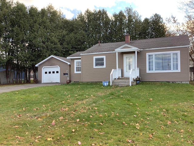 view of front of property with a front lawn, a garage, and an outbuilding