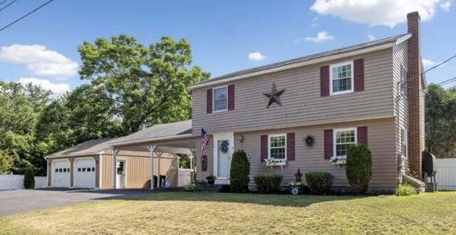 colonial house featuring a front yard and a garage