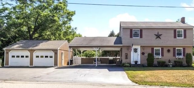 view of front of house featuring a front yard, a carport, and a garage