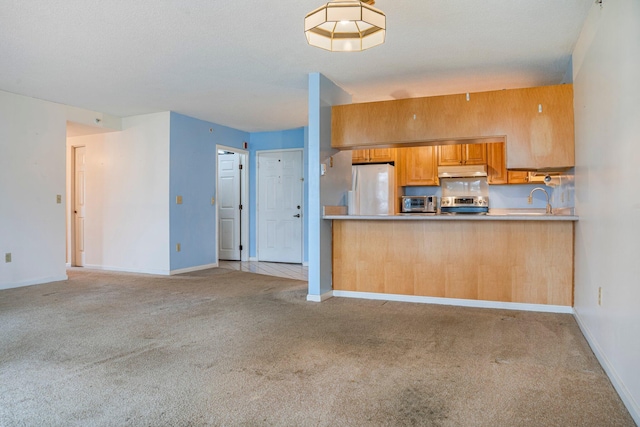 215 E Grand Ave Unit 206, Old Orchard Beach, ME 04064 - kitchen featuring stainless steel electric range oven, under cabinet range hood, light carpet, and freestanding refrigerator