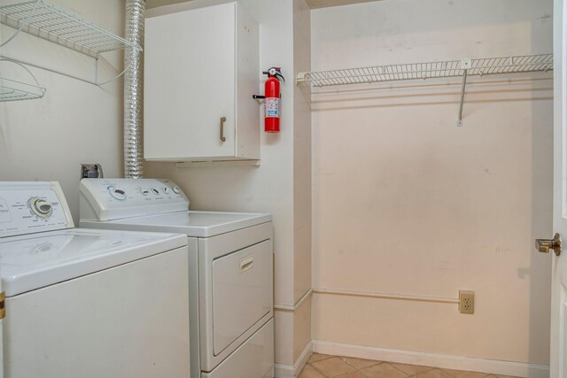 215 E Grand Ave Unit 206, Old Orchard Beach, ME 04064 - laundry area featuring independent washer and dryer, light tile patterned floors, cabinet space, and baseboards