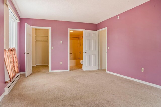 215 E Grand Ave Unit 206, Old Orchard Beach, ME 04064 - unfurnished bedroom featuring a baseboard heating unit, light colored carpet, baseboards, a spacious closet, and a closet