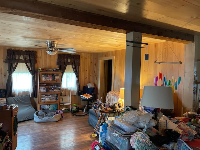 living room featuring wood-type flooring, plenty of natural light, wood walls, and ceiling fan