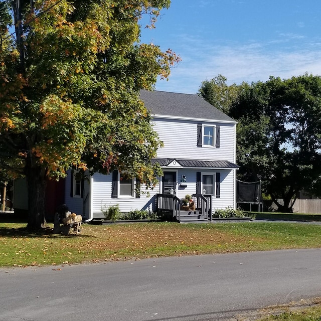 view of front of property featuring a trampoline and a front lawn