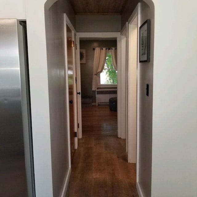 hallway with dark hardwood / wood-style flooring and radiator heating unit