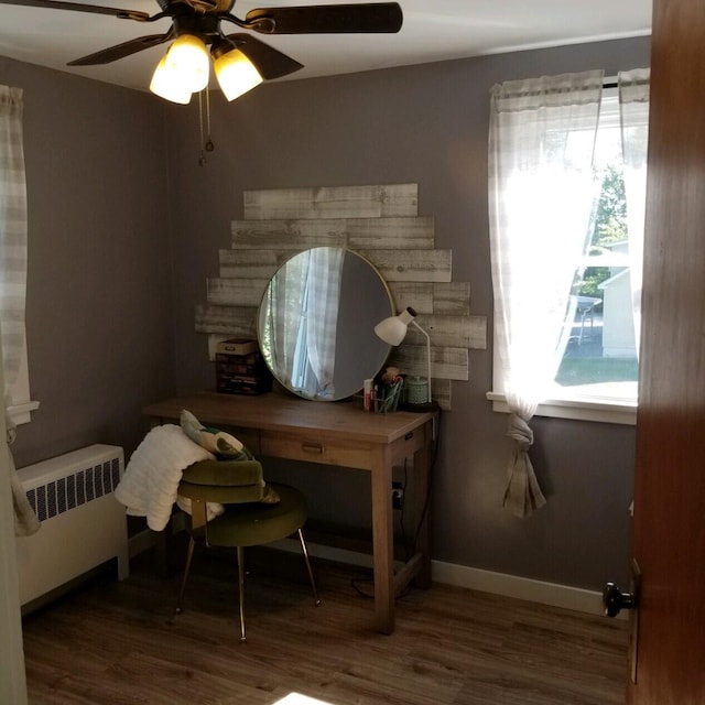 home office featuring ceiling fan, hardwood / wood-style floors, and radiator heating unit