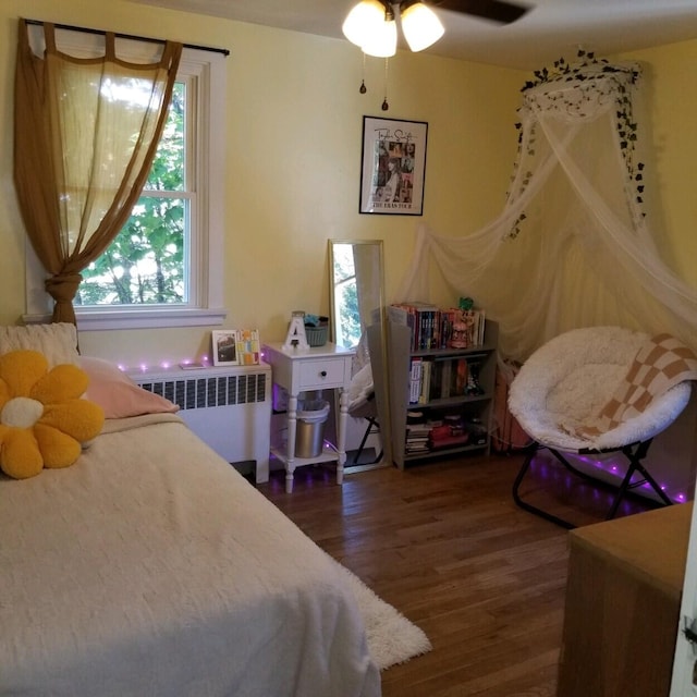 bedroom with radiator heating unit, ceiling fan, and dark wood-type flooring