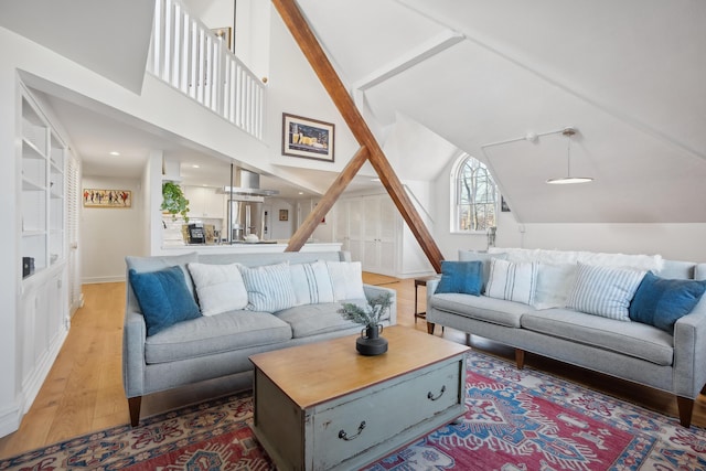 living area with high vaulted ceiling and wood finished floors
