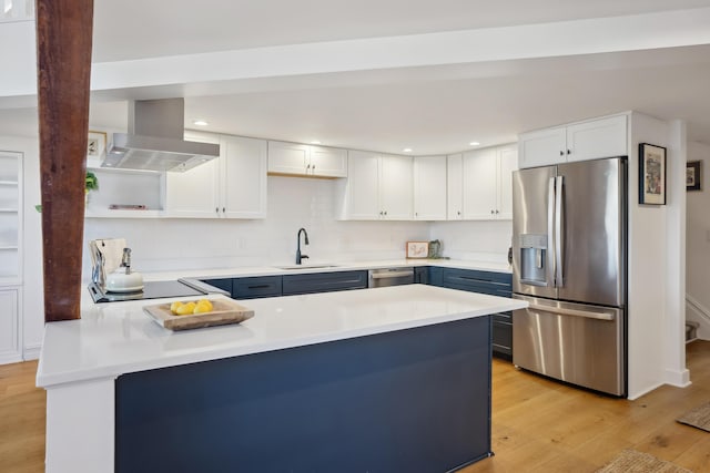 kitchen featuring a sink, open shelves, a peninsula, exhaust hood, and stainless steel appliances