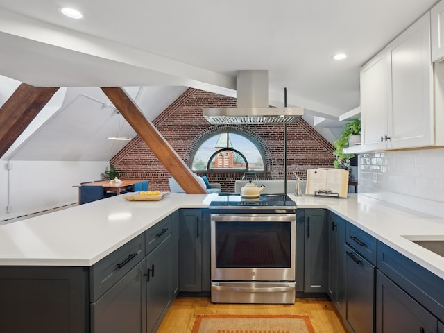 kitchen with stainless steel range with electric stovetop, light countertops, island exhaust hood, white cabinetry, and vaulted ceiling with beams