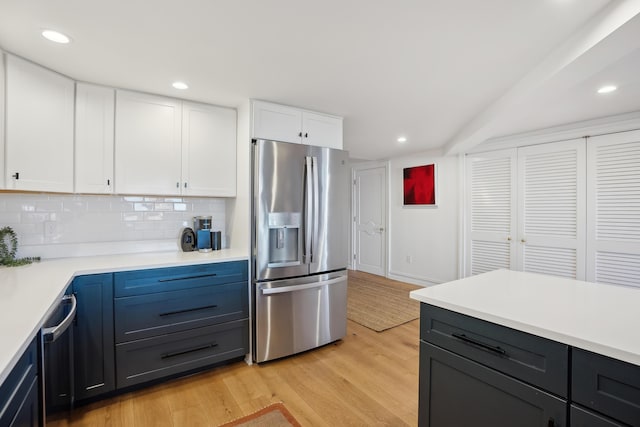 kitchen featuring decorative backsplash, white cabinets, light countertops, light wood-style floors, and stainless steel fridge with ice dispenser