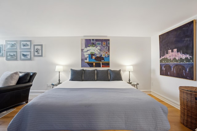 bedroom with baseboards and wood finished floors