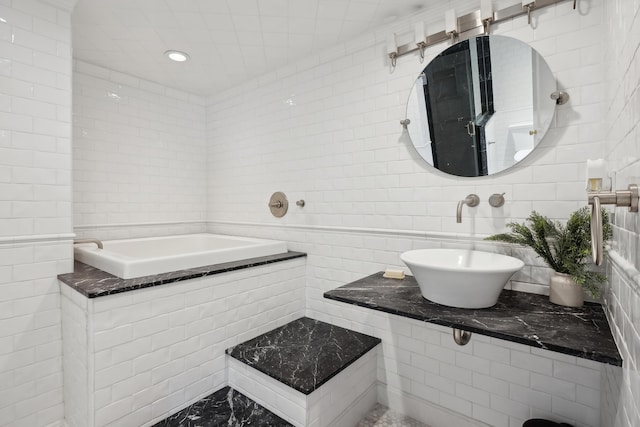 full bathroom with a sink and tile walls