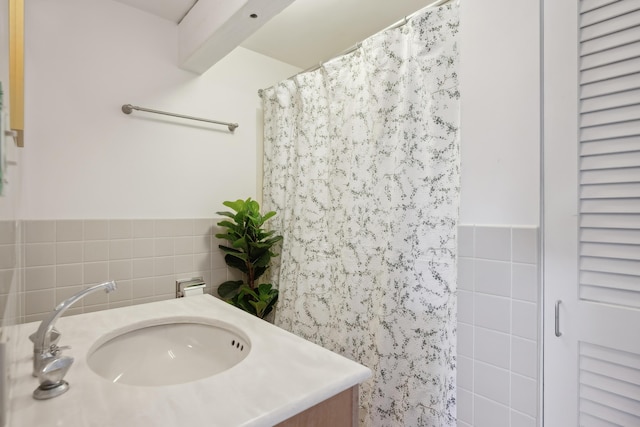 bathroom with wainscoting, vanity, tile walls, and a shower with shower curtain
