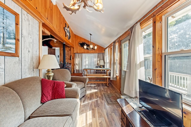 living room featuring wooden walls, an inviting chandelier, dark wood-type flooring, and high vaulted ceiling