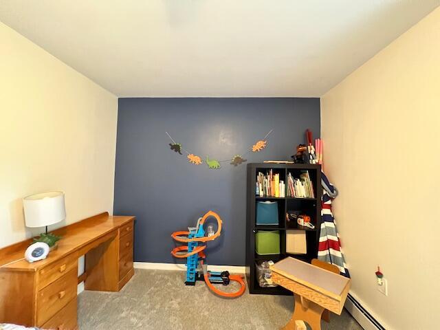 rec room featuring light colored carpet and a baseboard heating unit