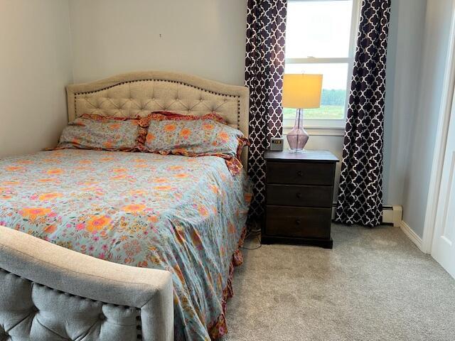 carpeted bedroom featuring baseboard heating