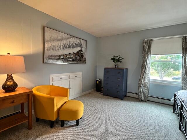 living area with baseboard heating and carpet