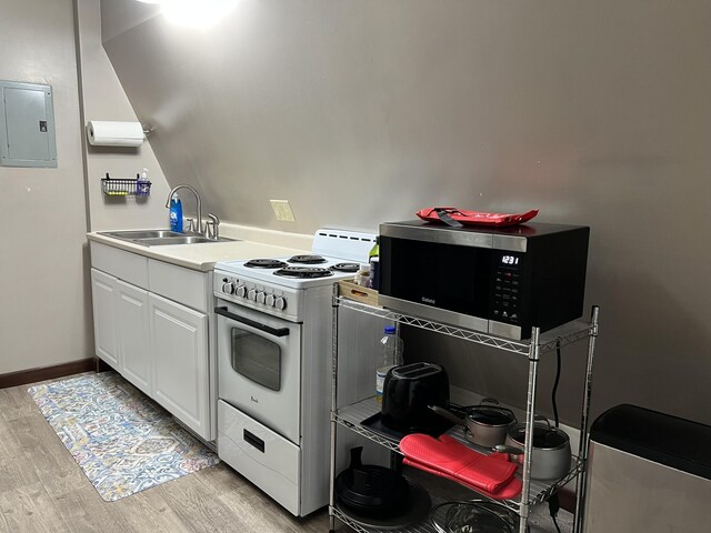 kitchen featuring light hardwood / wood-style floors, white cabinetry, electric panel, white gas stove, and sink