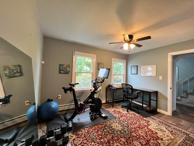 workout room with a baseboard radiator, ceiling fan, and hardwood / wood-style flooring