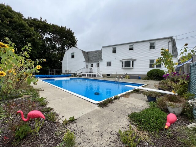 view of swimming pool with a patio and a diving board