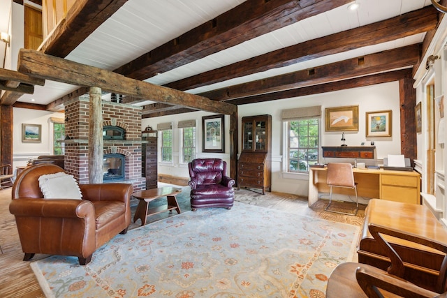 living room with a brick fireplace, light hardwood / wood-style flooring, and beam ceiling