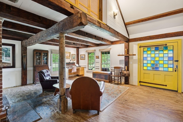 living room with lofted ceiling with beams and light hardwood / wood-style floors