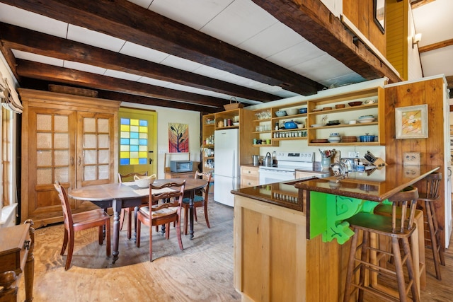 kitchen featuring beamed ceiling, white appliances, french doors, light hardwood / wood-style flooring, and a kitchen breakfast bar