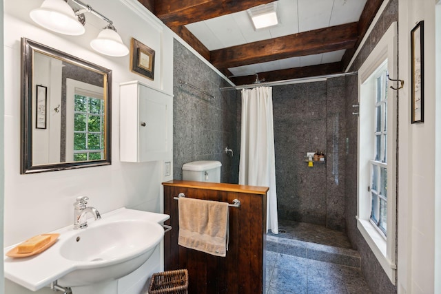 bathroom with tile walls, curtained shower, beamed ceiling, toilet, and sink