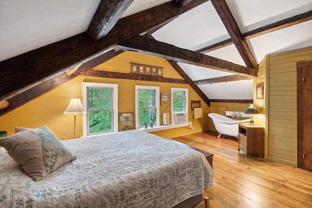 bedroom featuring light wood-type flooring, vaulted ceiling with beams, and wooden walls