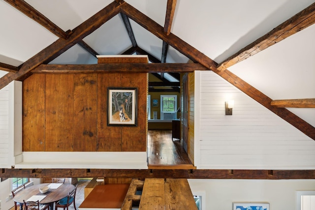 room details featuring wooden walls and beamed ceiling