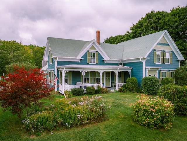 view of front of home with a front yard and covered porch