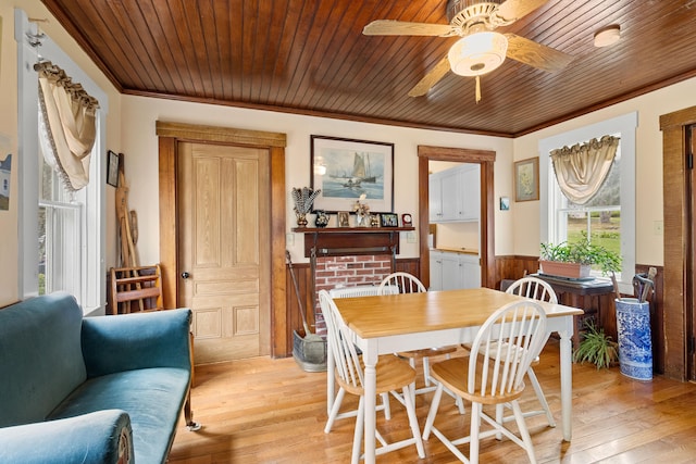 dining room with wooden ceiling, crown molding, and light hardwood / wood-style flooring