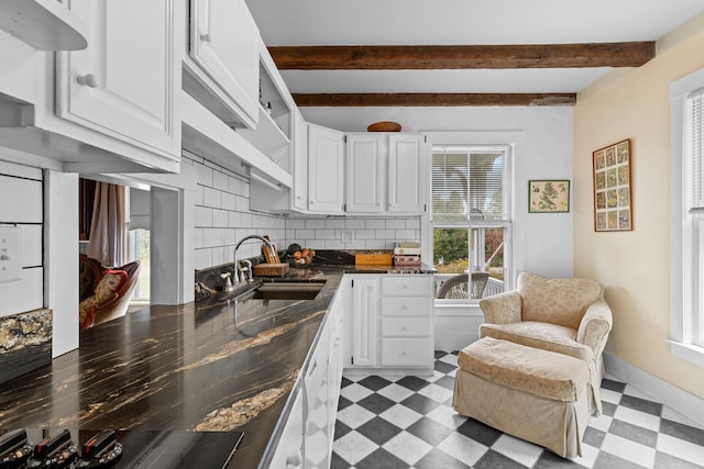 kitchen with beamed ceiling, sink, decorative backsplash, and white cabinetry